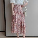 シフォンシャツ と 花柄のティアードスカートを着た女性