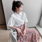 シフォンシャツ と 花柄のティアードスカートを着た女性