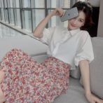 シフォンシャツ と 花柄のティアードスカートを着た女性