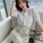 Vネックのシフォンシャツ と花柄のサマースカートを着た女性