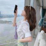 Vネックのシフォンシャツ と花柄のサマースカートを着た女性