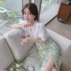 Vネックのシフォンシャツ と花柄のサマースカートを着た女性