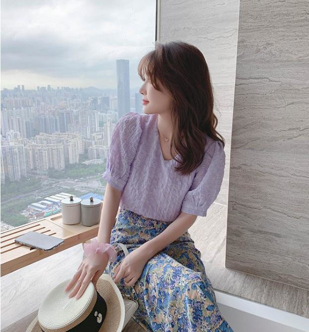 シフォンシャツと花柄スカートを着た女性