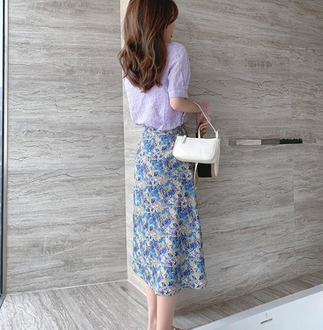 シフォンシャツと花柄スカートをはいた女性
