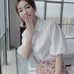 シフォンシャツ と 花柄のティアードスカートを着た女性