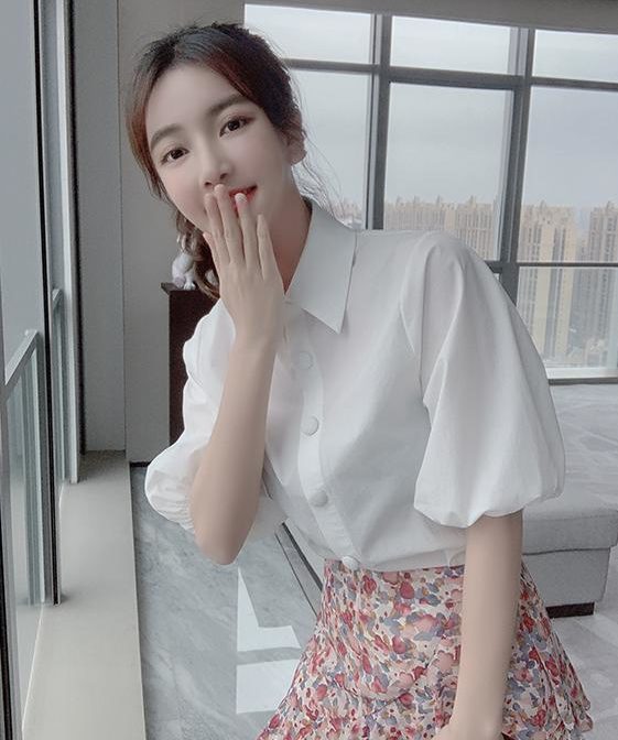 シフォンシャツ と 花柄のティアードスカートを着た女性