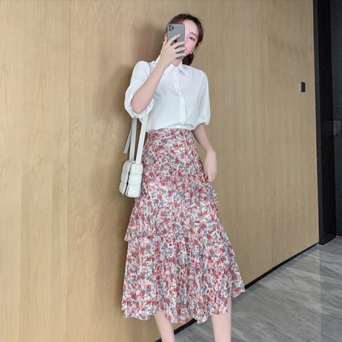 シフォンシャツ と 花柄のティアードスカートを着た女性