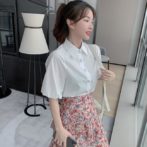 シフォンシャツ と 花柄のティアードスカートを着た女性