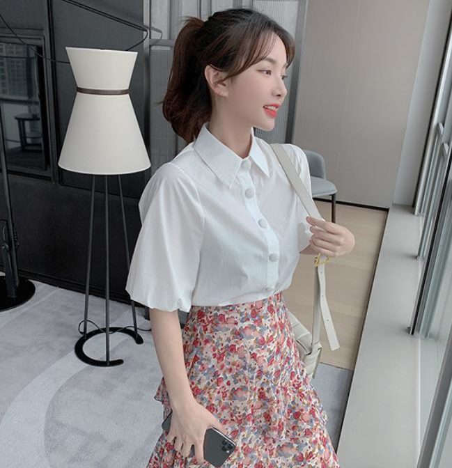 シフォンシャツ と 花柄のティアードスカートを着た女性