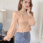 ランタンスリーブの長袖トップスを着た女性